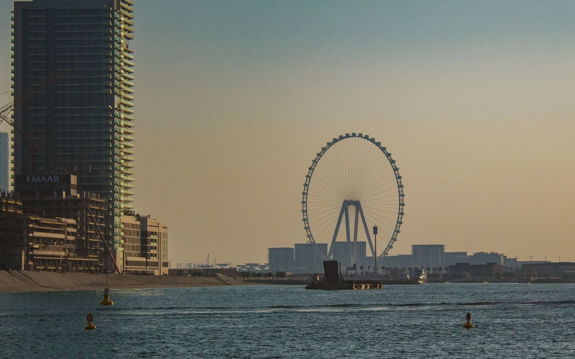 Panoráma Dubaja s obřím kolom pri západe slnka