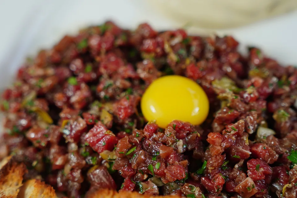 BookNoFees: Ukážková fotografia: Steak tartare s vaječným žĺtkom, podávaný s opečeným chlebom